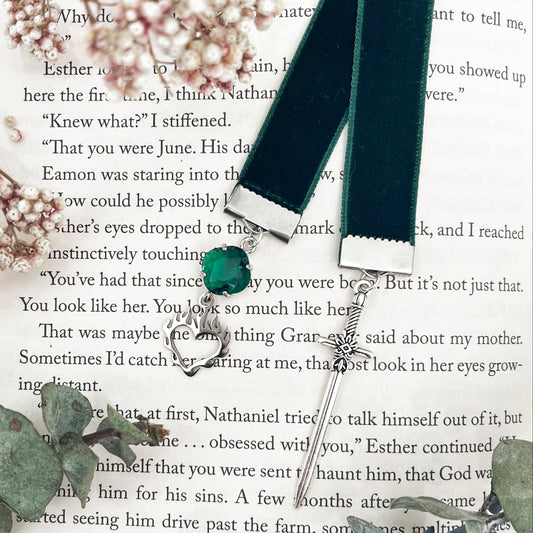 Fireheart bookmark, inspired by throne of glass with a green gem and flame heart charm on one end and a silver sword on the other end of a emerald green ribbon