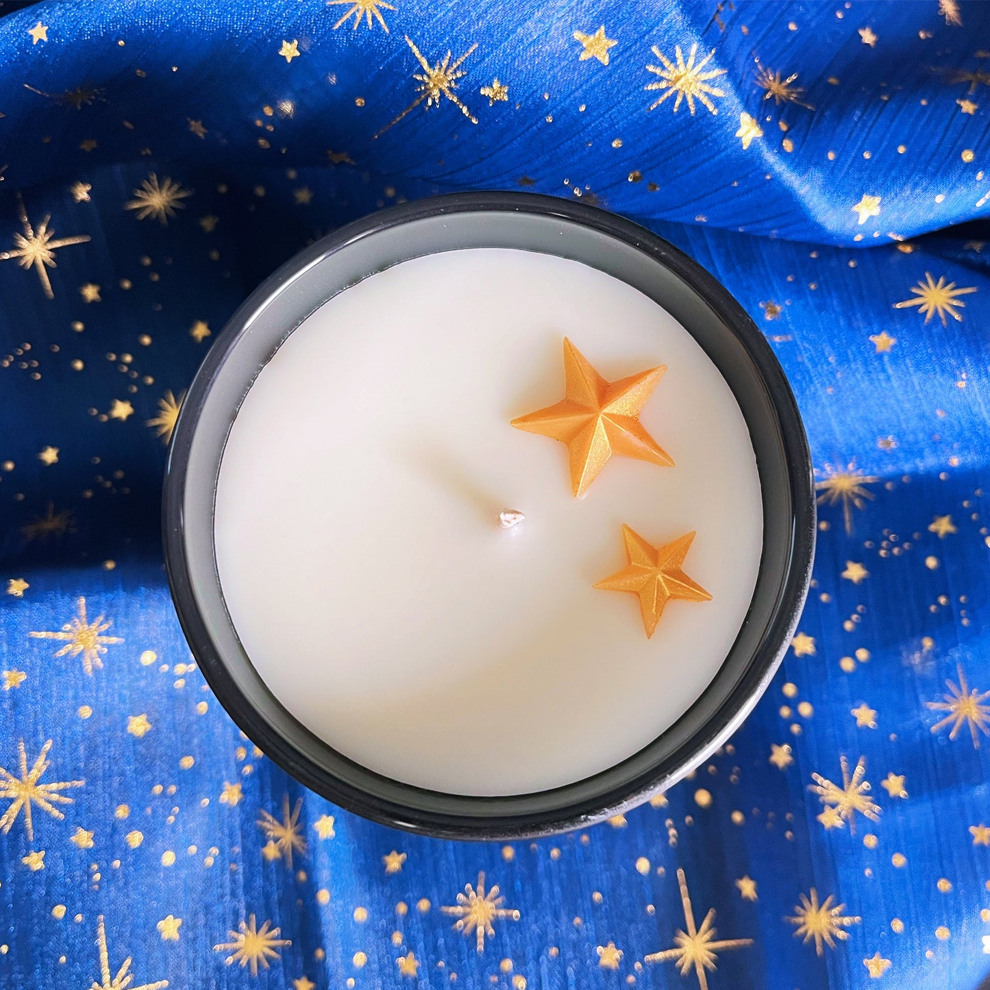 op-down view of City of Starlight bookish candle showing white soy wax surface topped with gold shimmering stars