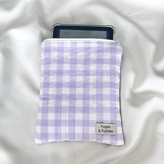 Purple and white checkered pouch with a tablet inside on a white fabric background