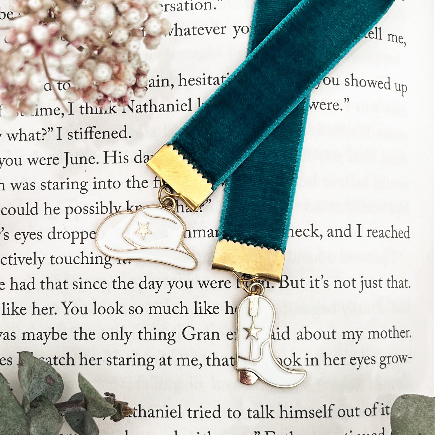 Teal ribbon with gold clasp on a white and gold cowboy boot and hat