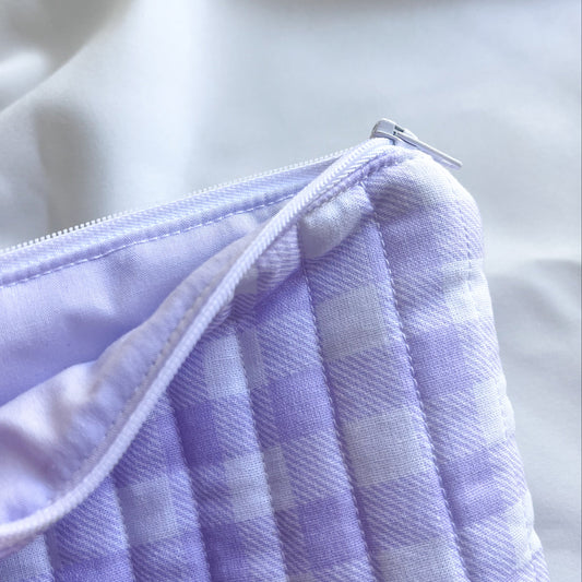 Close-up of a purple checkered fabric with a zipper on a light background