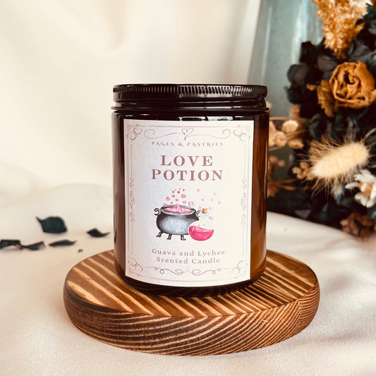 Candle labeled 'Love Potion' on a wooden coaster with decorative elements in the background.