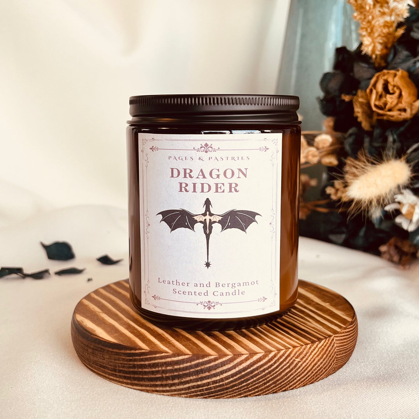 Dragon Rider bookish candle in amber glass jar with leather and bergamot scent, featuring dragon design on label